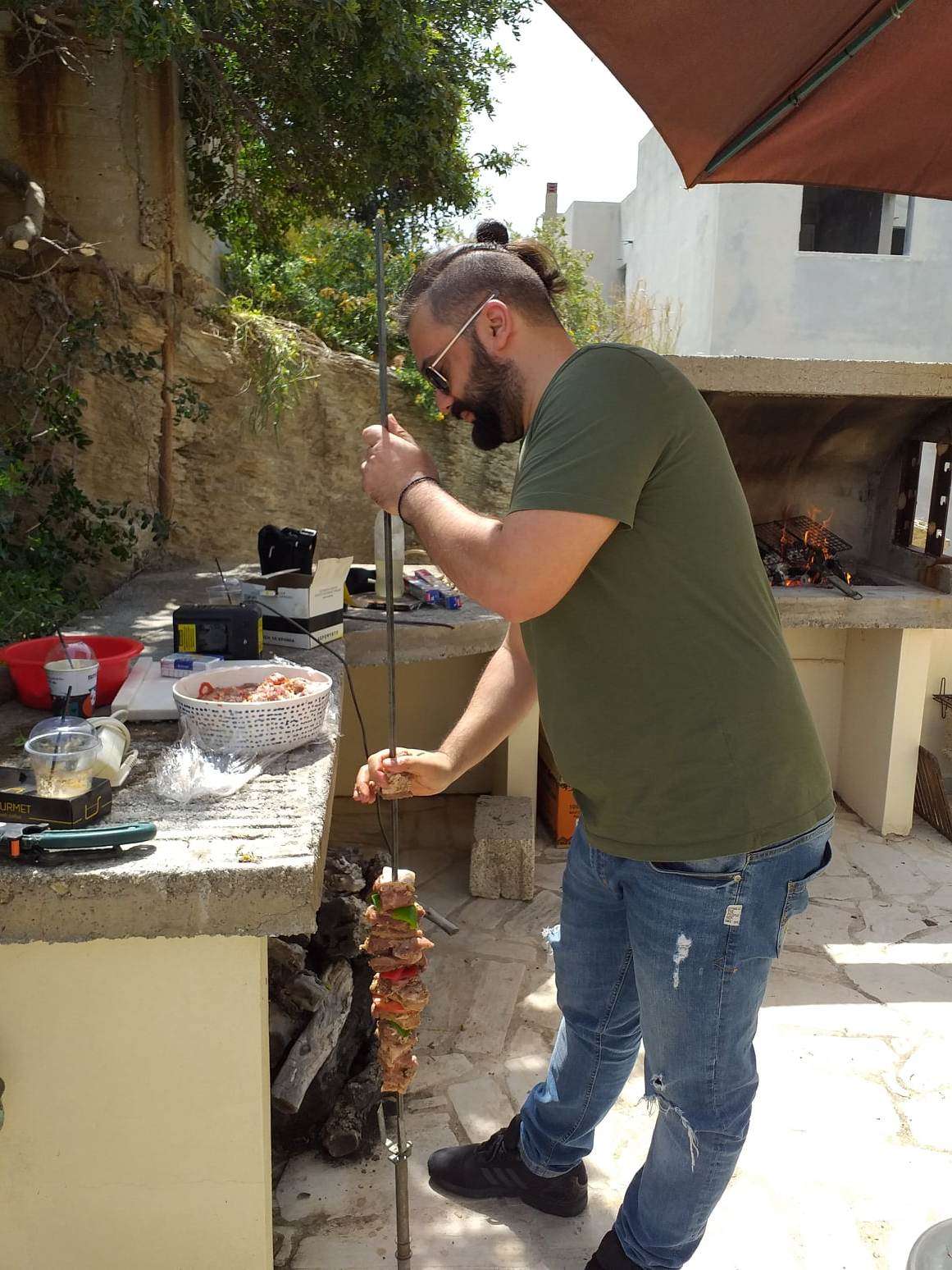 Chef préparant du kontosouvli xoirino au barbecue
