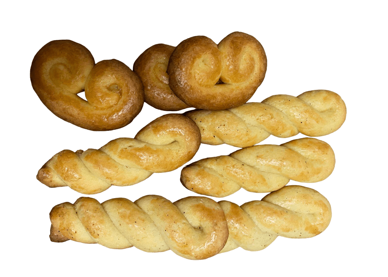  Des petits pains briochés sucrés, appelés Tsourekakia, empilés sur une assiette blanche.