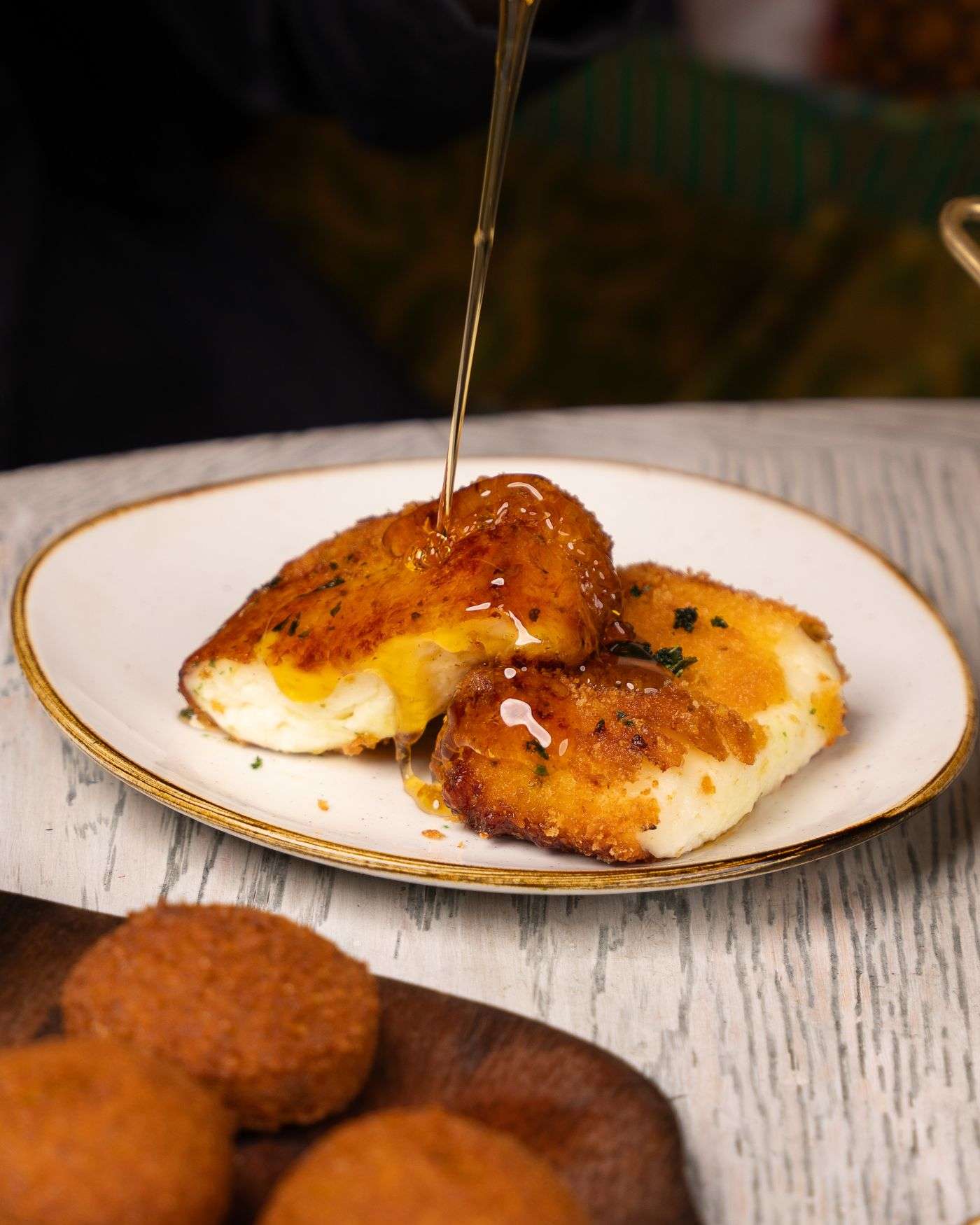 Saganaki, fromage grec frit doré arrosé de miel et de sésame