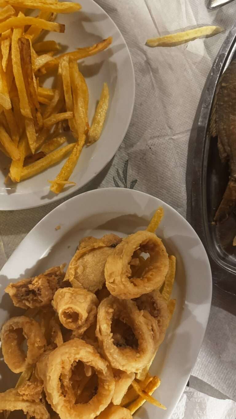 Assiette de kalamarakia tiganita, des calamars frits, dans une taverne crétoise, avec des frites maison et un poisson frit