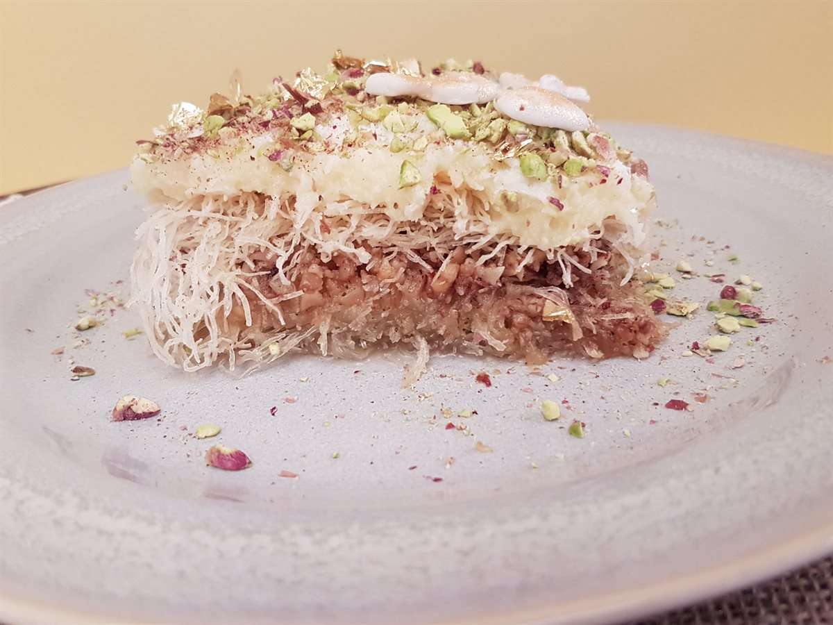 Part d'ekmec kadaifi en couches : kadaifi aux noix, crème pâtissière, chantilly et pistaches concassées