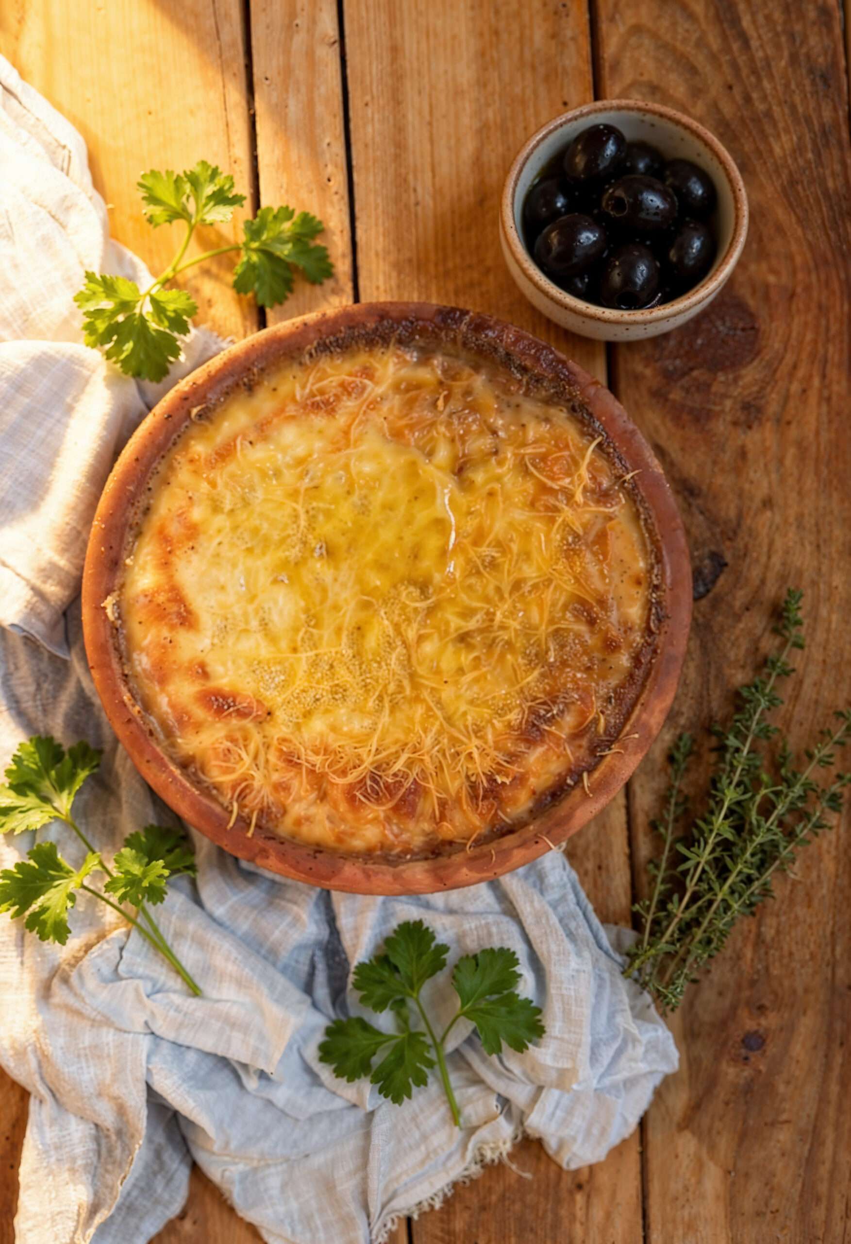 Accueil - Recettes Grecques 1 Moussaka crétoise au four, gratinée dans son plat en terre cuite, avec olives noires et herbes