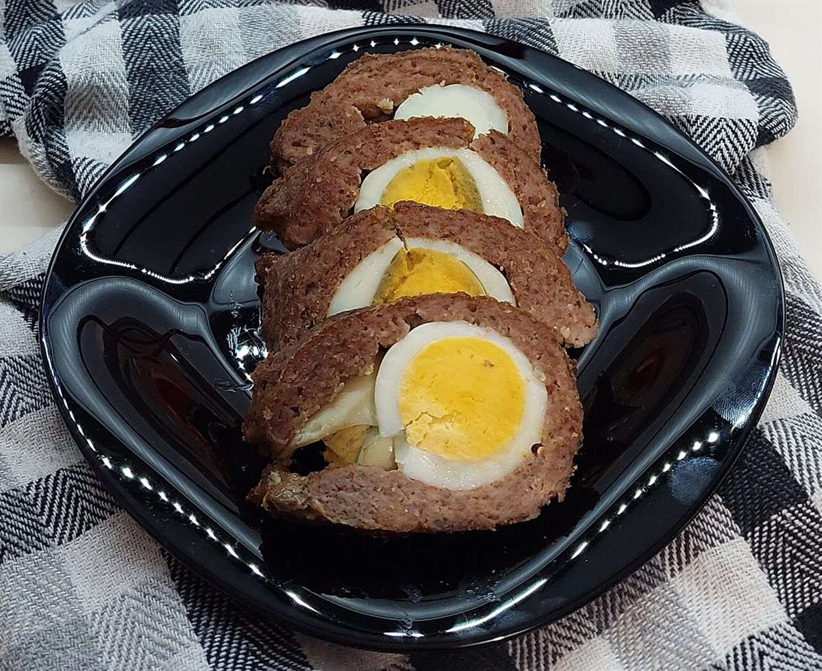 Rolo kimas, rouleau de viande hachée farci aux œufs durs, coupé en tranches montrant l'œuf au centre