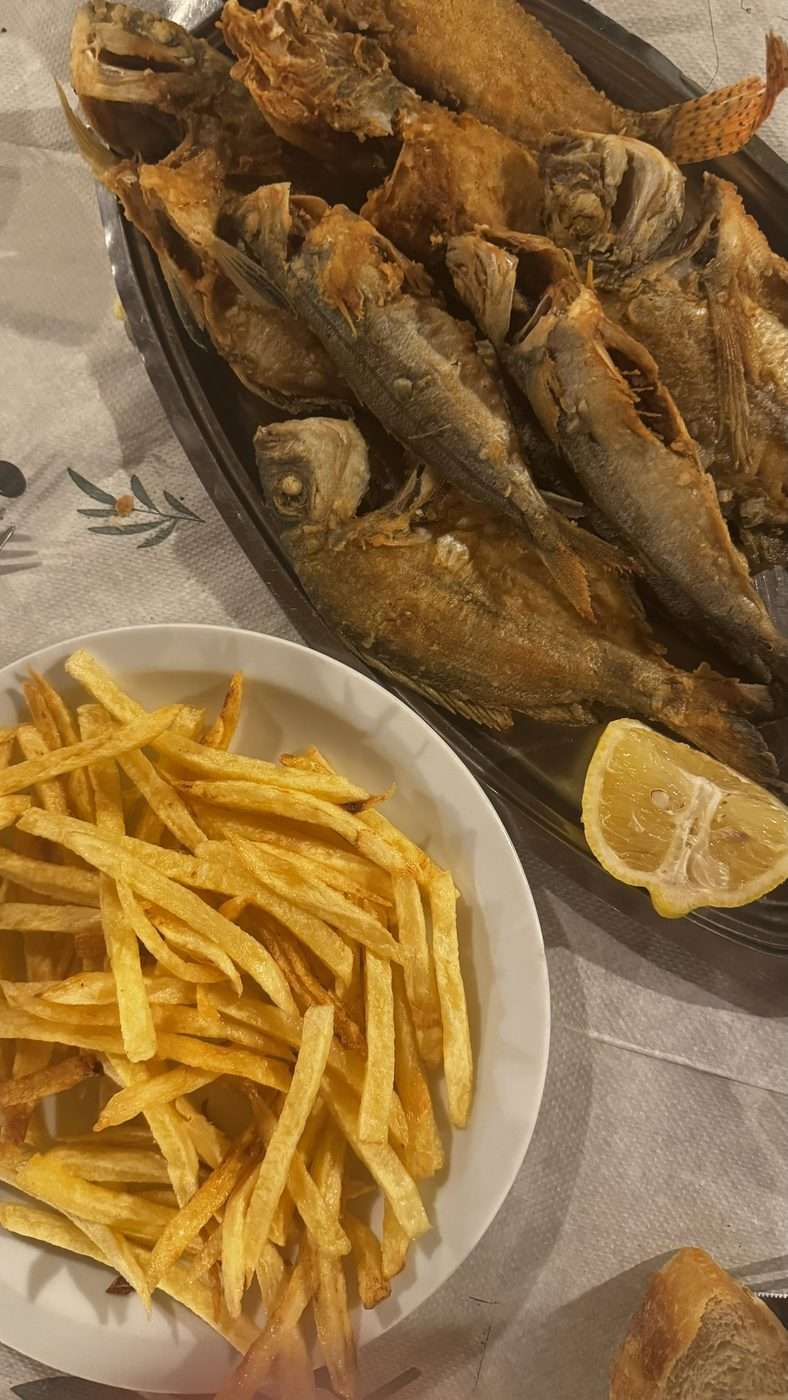 Plat de friture de petits poissons servi avec des frites, du citron et du pain dans une psarotaverna grecque