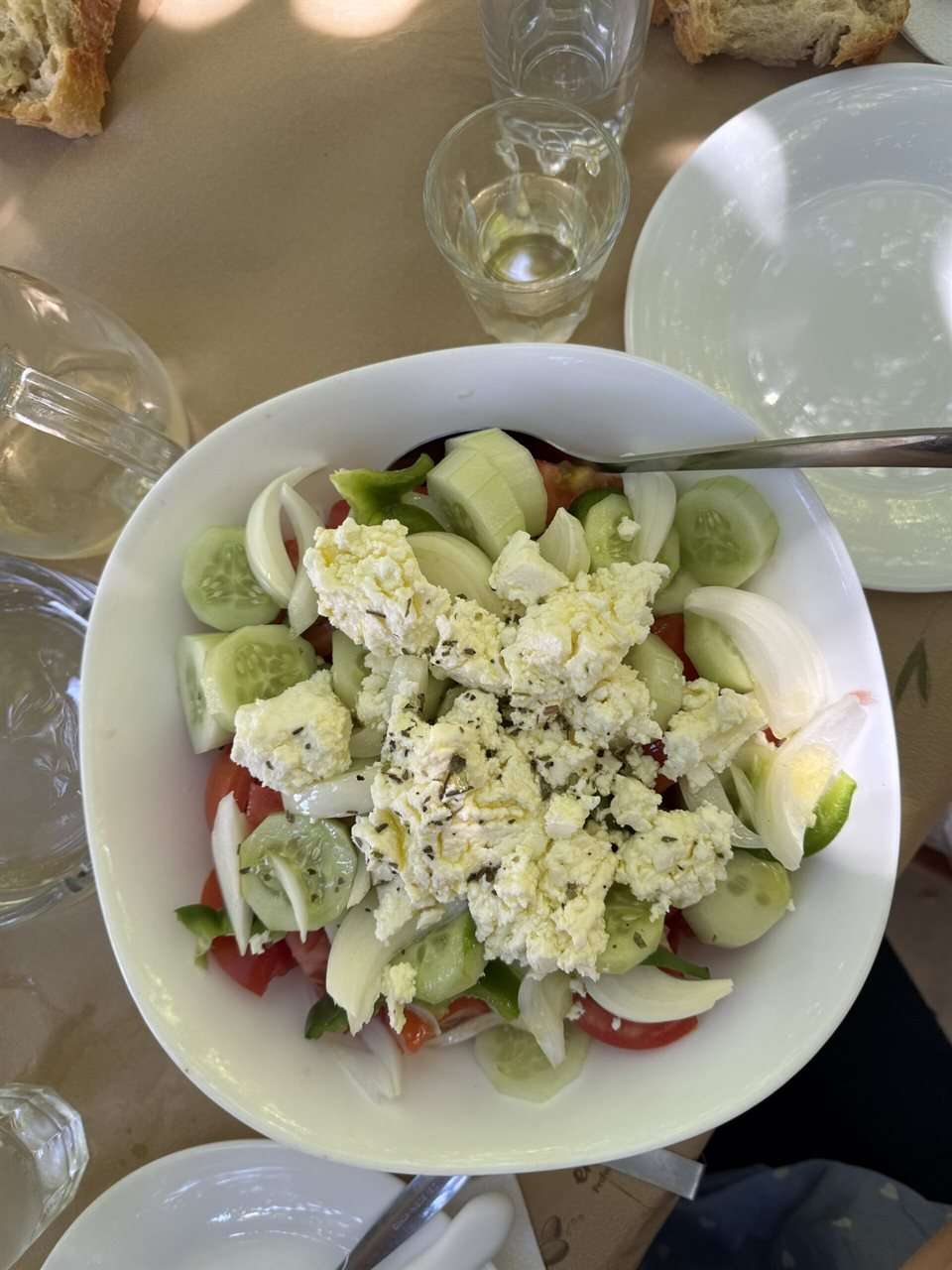 Salade grecque horiatiki dans un grand saladier : tomates, concombre, poivron vert, oignon, olives Kalamon et feta