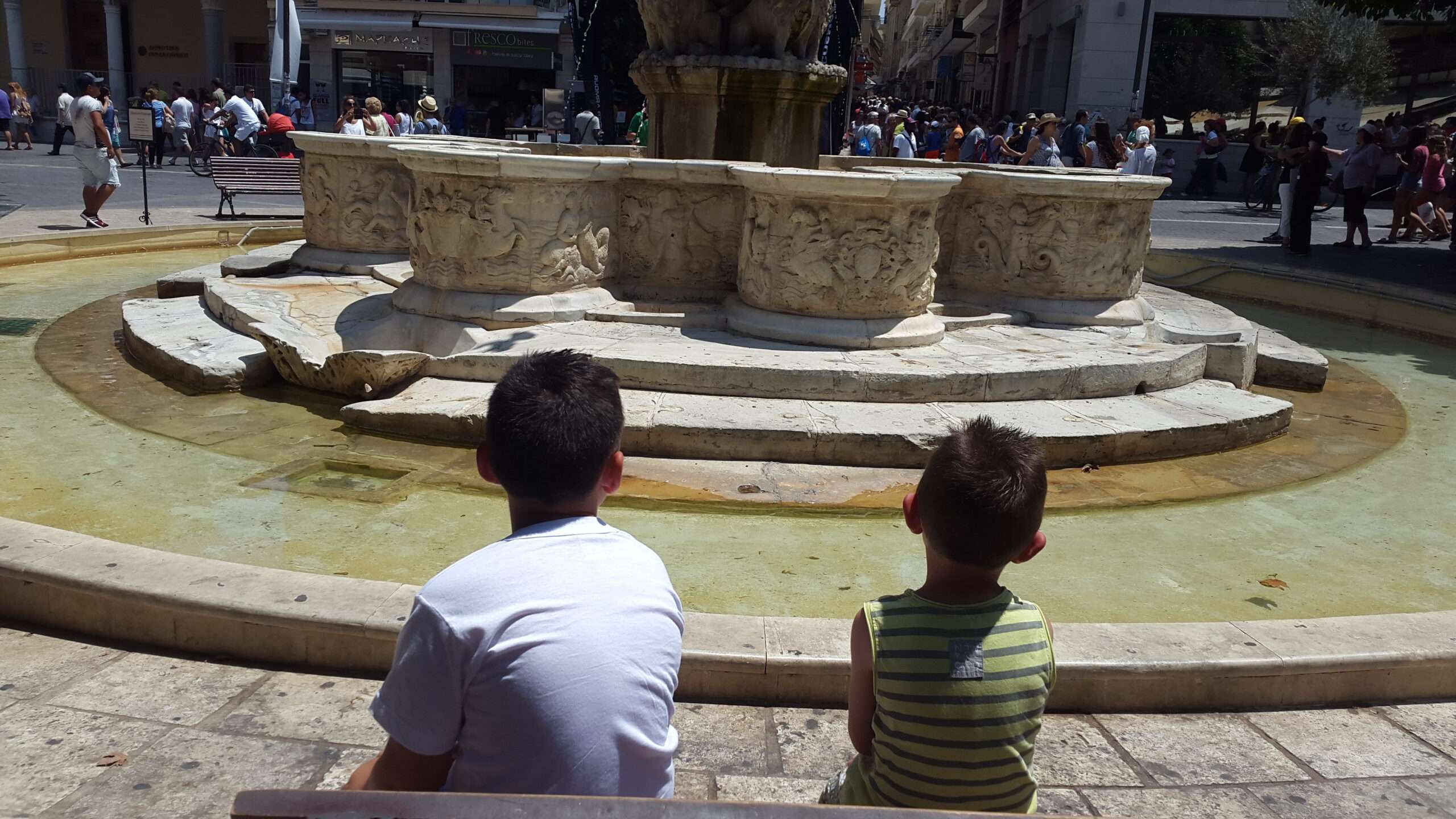 Ce que Socrate dirait de l'intelligence artificielle 16 Les deux fils de Maria assis devant la fontaine Morosini, place des Lions, à Héraklion