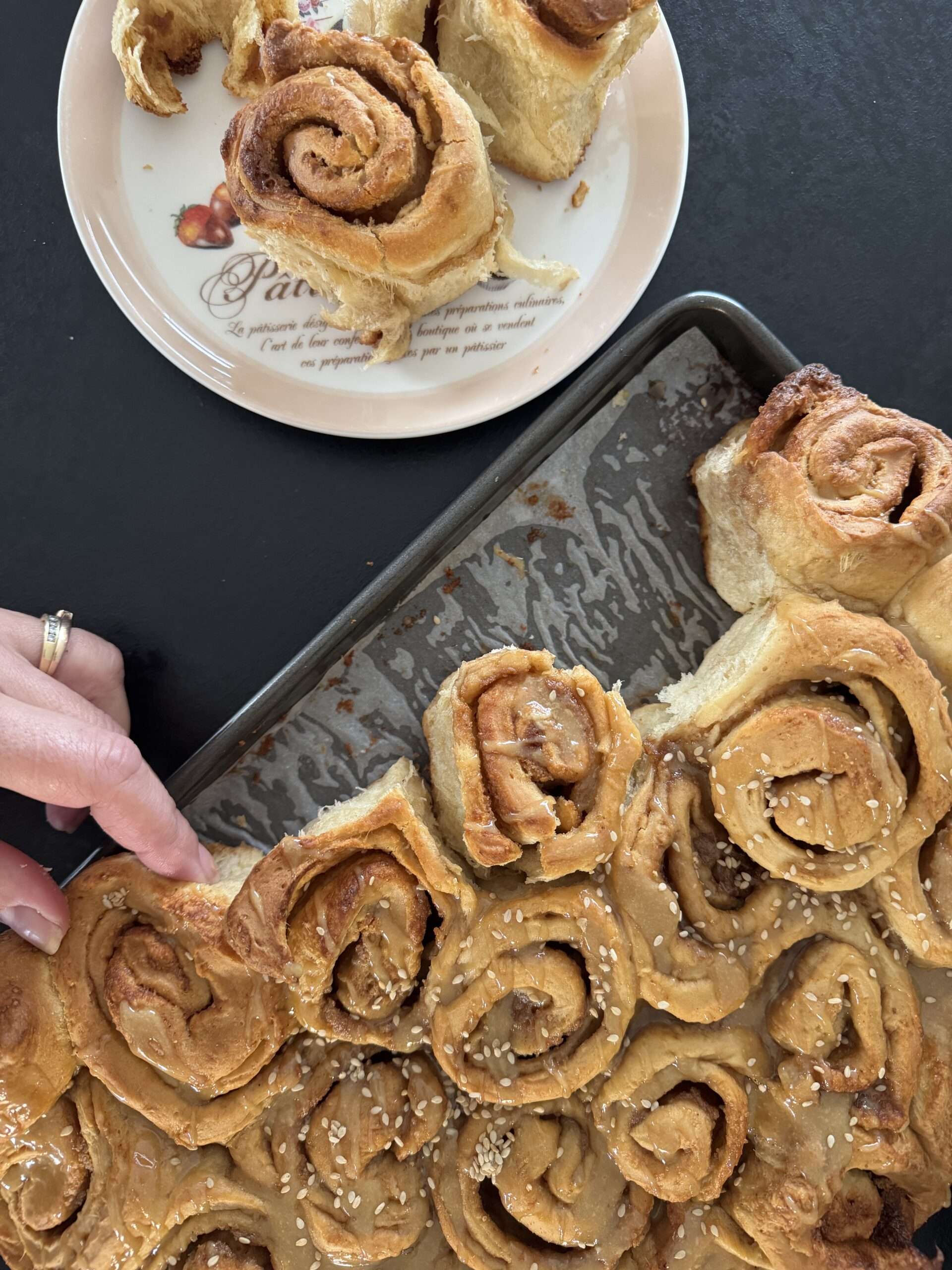 Plaque de cinnamon rolls grecs nappés de tahini et miel de thym, parsemés de sésame