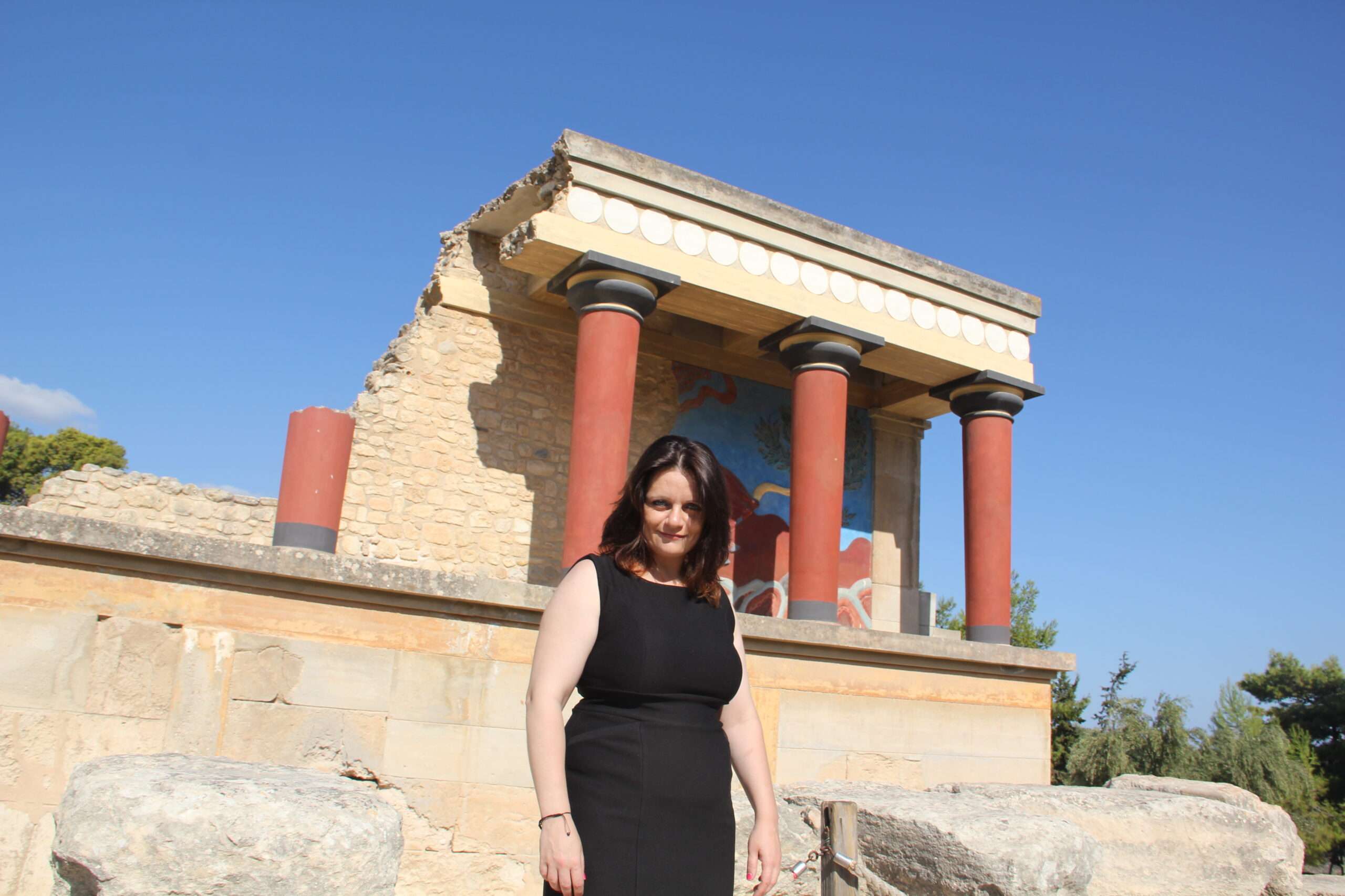 Ce que Socrate dirait de l'intelligence artificielle 6 Maria Thalassinaki devant les colonnes rouges et la fresque du taureau, palais de Knossos