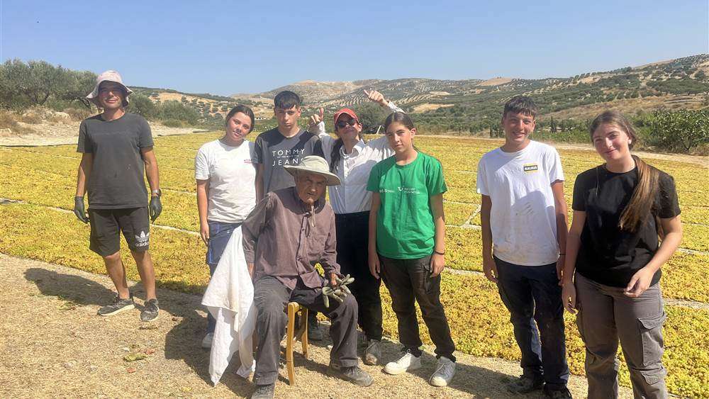 La famille Agrimanakis au complet devant les aires de sechage