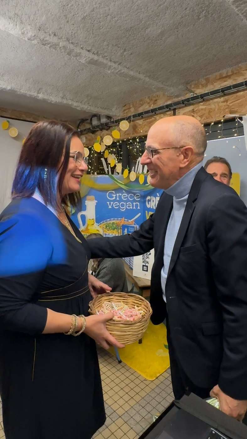 Un invité choisit son bonbon aux mantinades à l'accueil de la soirée de lancement de Grèce vegan