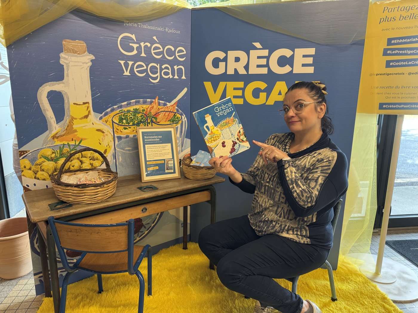 Le coin photo jaune et bleu aux couleurs du livre Grèce vegan, installé à la boutique de Messei