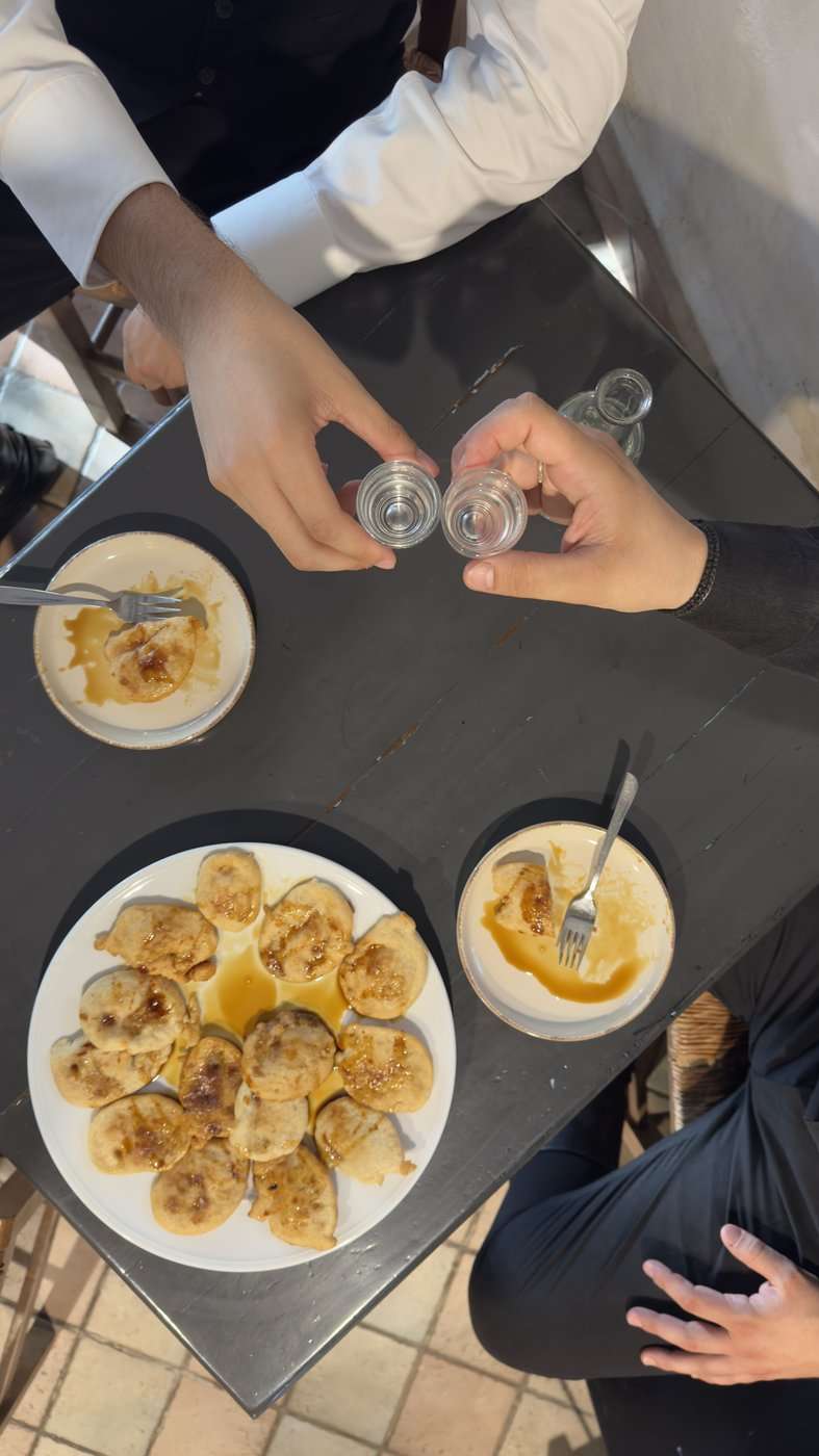 Grèce vegan, mon livre : la visite en avant-première, trois jours avant sa sortie 22 Des kalitsounia et des petits verres de raki sur une table noire, en Crète