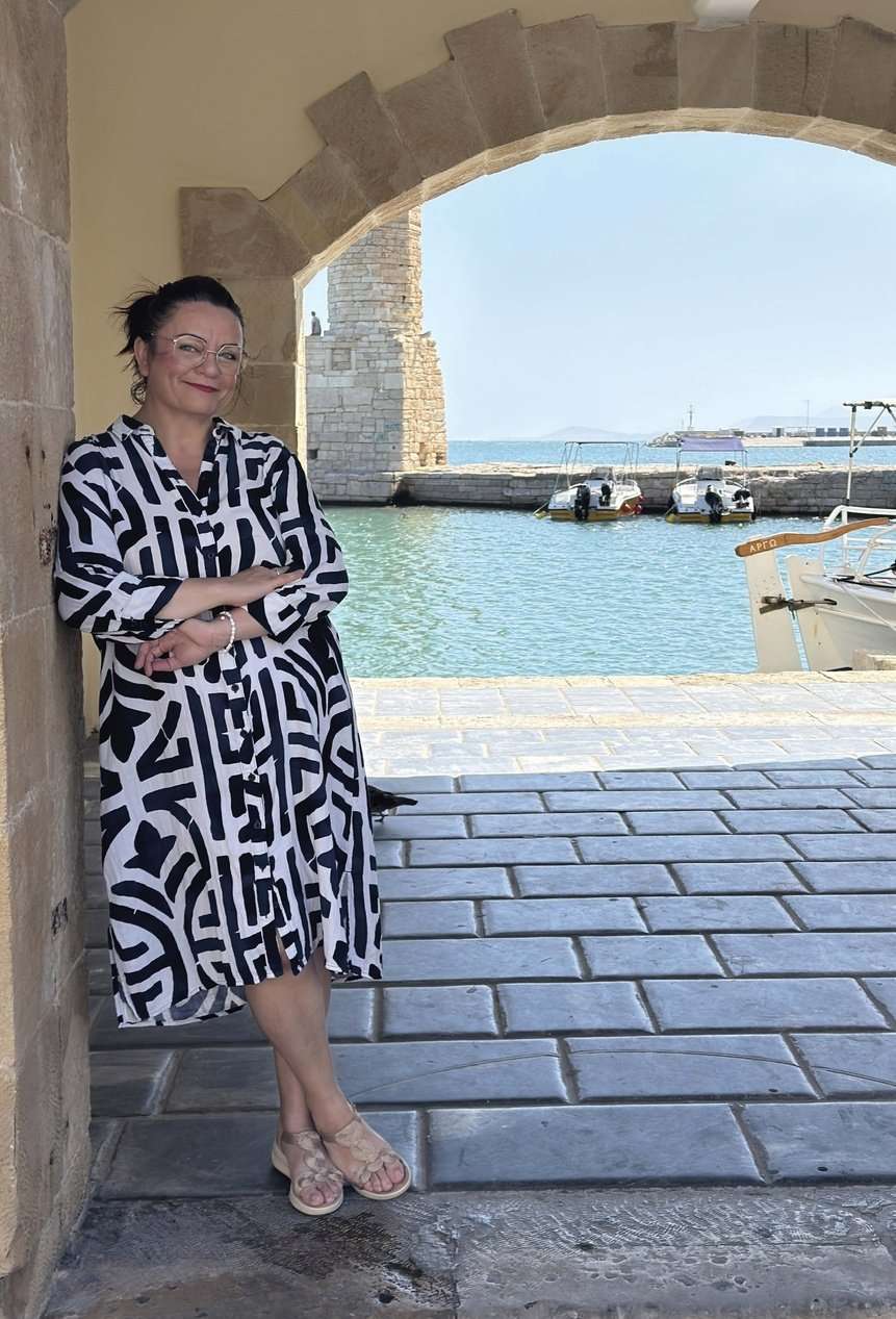 Maria Thalassinaki-Radoux, autrice du livre Grèce vegan, sous une arche du port de Réthymnon