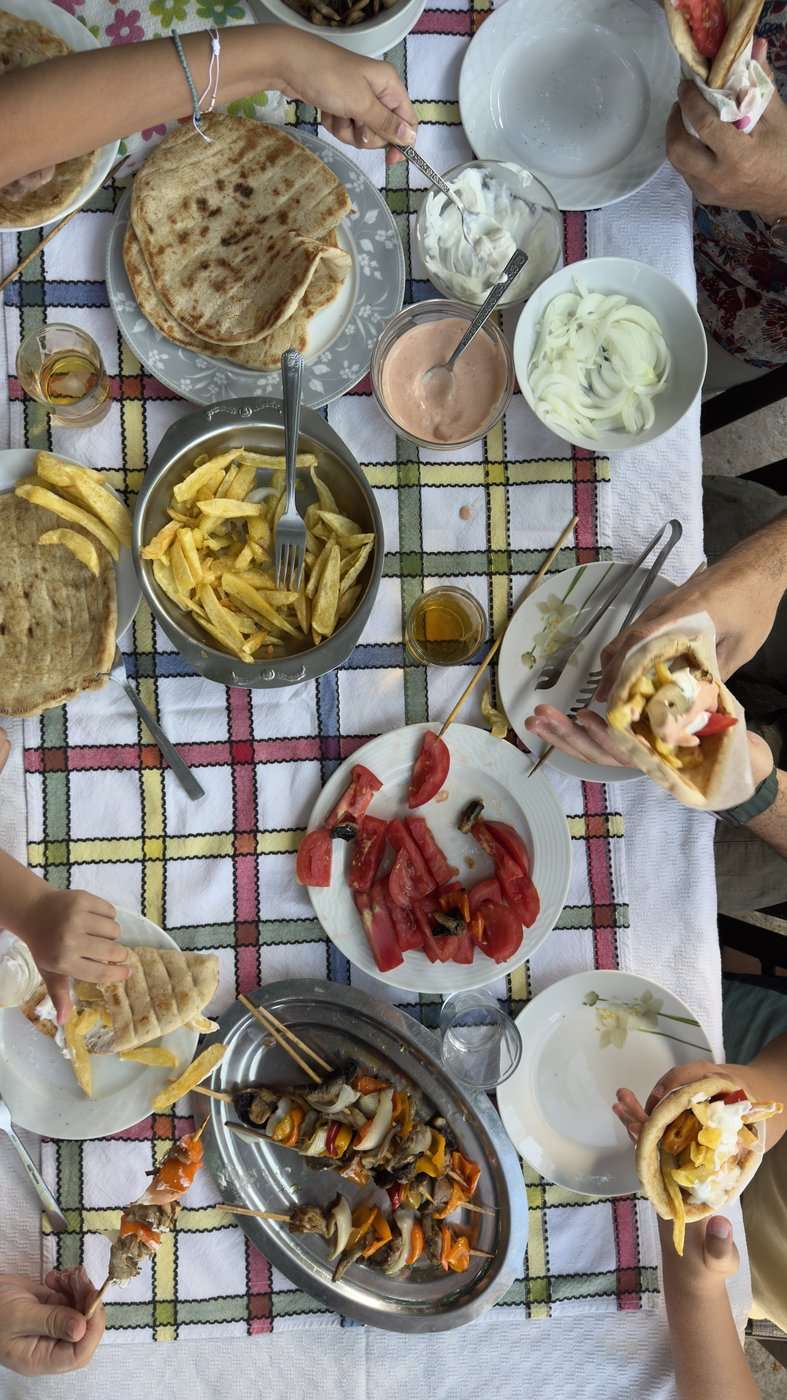 Grèce vegan, mon livre : la visite en avant-première, trois jours avant sa sortie 17 Une table partagée en Crète, vue du dessus : pita, tzatziki, tomates, mezzés, pendant les photos du livre Grèce vegan